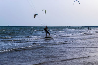 Man surfing in sea against sky