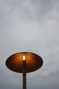 Illuminated lamp post against sky