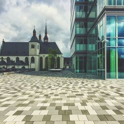 Buildings in city against cloudy sky