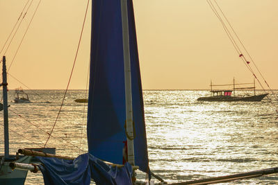 Sailboat in sea at sunset