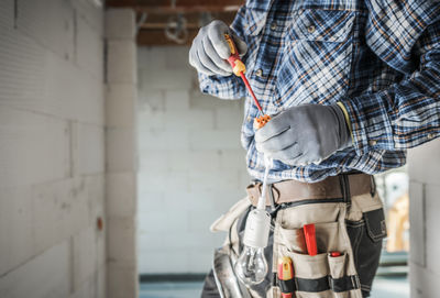 Midsection of man standing against wall