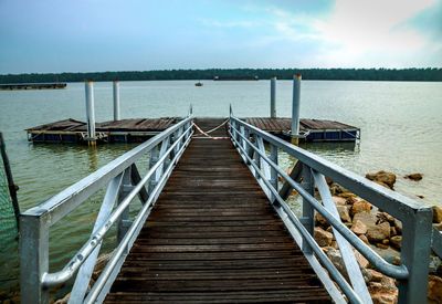 View of wooden pier over sea against sky