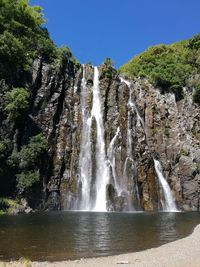 Low angle view of waterfall against sky