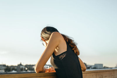 Young woman against clear sky