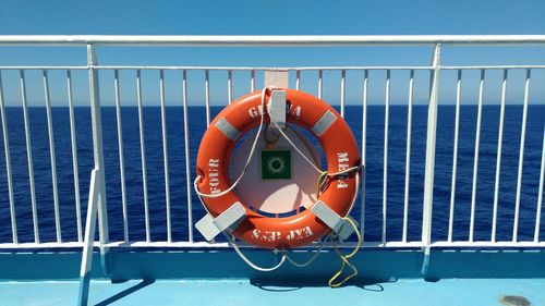 Rope tied to railing by sea against clear sky