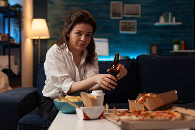 Young woman using mobile phone while sitting at restaurant