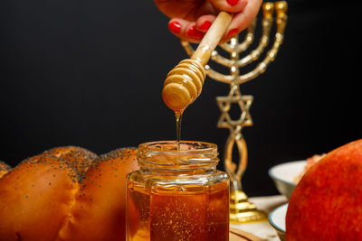 Midsection of woman holding drink on table