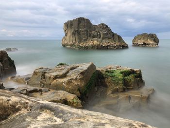 Scenic view of rocks in sea against sky