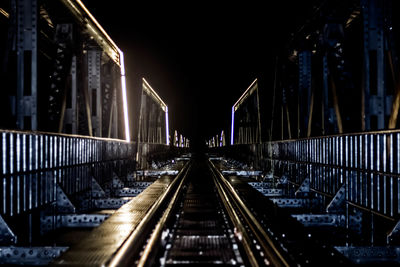 Railway bridge against sky at night