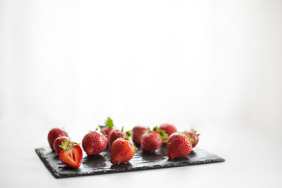 Close-up of fruits in plate against white background