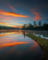 Scenic view of lake against orange sky