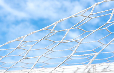 Low angle view of soccer net against sky