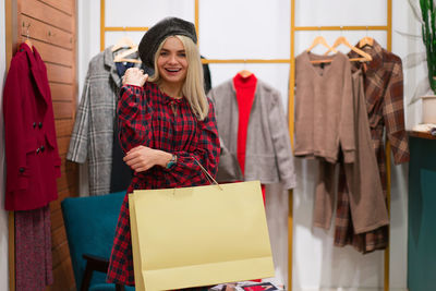 Happy young woman standing in clothing store