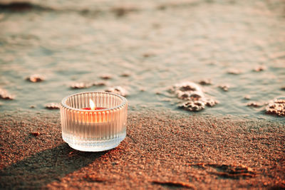 Close-up of drink on sand at beach