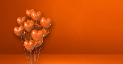 High angle view of red chili peppers on table against orange background