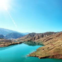 Scenic view of lake and mountains against blue sky