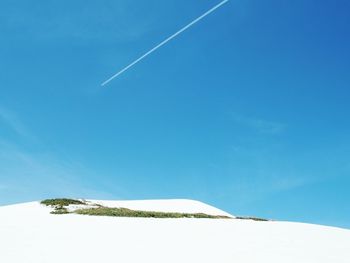 Vapor trail against clear blue sky