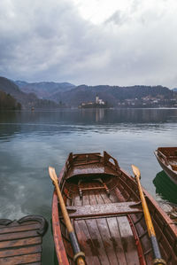 Scenic view of lake and boats against sky