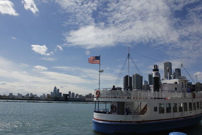 Sailboat on sea by city against sky