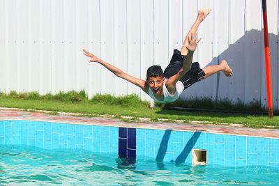 Portrait of boy jumping in swimming pool