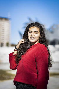 Portrait of smiling teenage girl standing in city