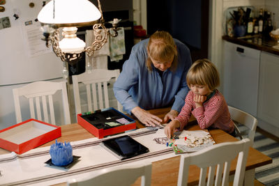 Senior woman playing board game with grandson at home