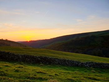 Scenic view of field against sky during sunset