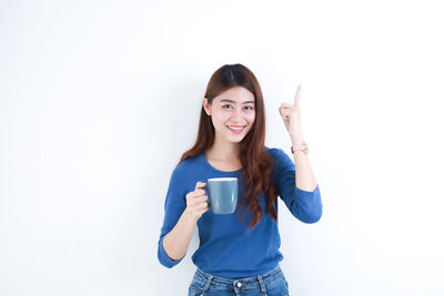 Portrait of smiling young woman against white background