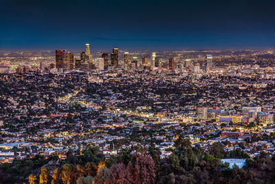 Illuminated cityscape against sky at night