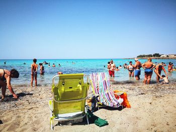 People on beach against clear sky