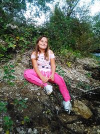 Portrait of young woman sitting on rock