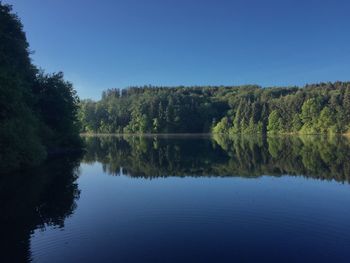 Scenic view of lake against clear blue sky