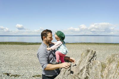 Wide angle view of a father and daughter playing together on a beach