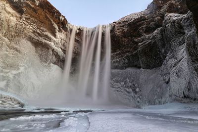 Scenic view of frozen waterfall against clear sky