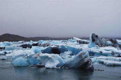 Frozen lake against clear sky