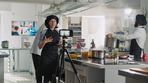 Female chef vlogging in kitchen