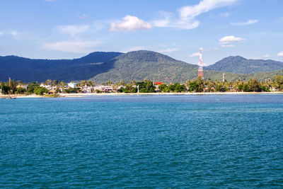 Scenic view of sea by mountains against sky