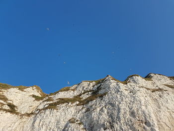 Low angle view of rock formation against clear blue sky