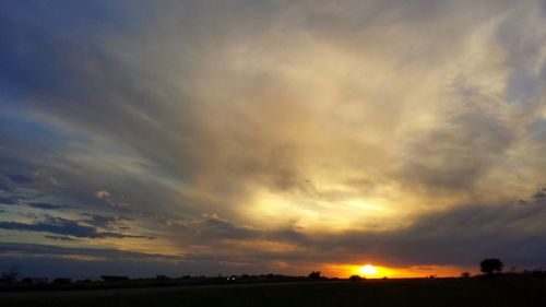 Scenic view of silhouette field against sky during sunset