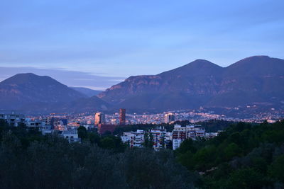 High angle view of townscape by mountains against sky