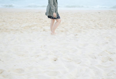 Low section of woman walking on beach