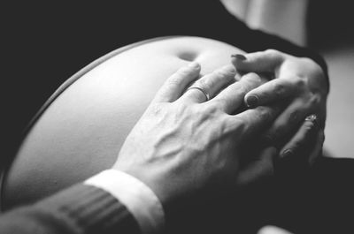 Close-up of husband and wife touching pregnant belly