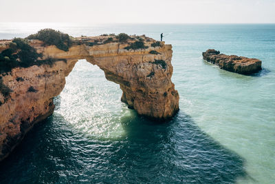 Rock formations by sea against sky