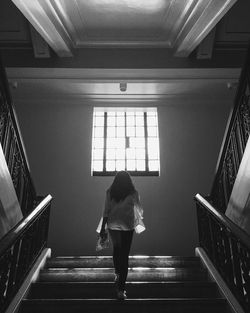 Woman standing on escalator