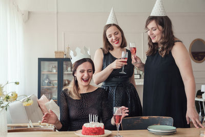 Happy friends sitting on table