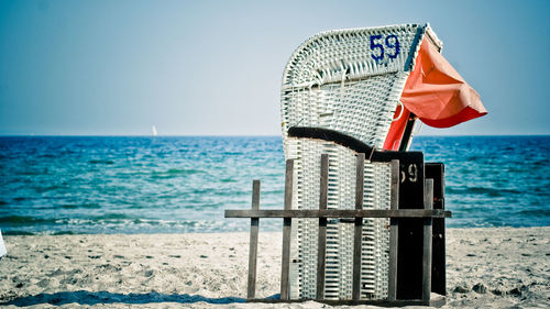 Hooded beach chair against clear sky