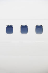 Close-up of airplane window against sky