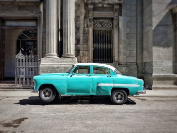 Vintage car on street against building in city