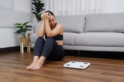 Young woman sitting on sofa at home