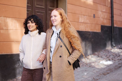 Smiling young women walking in street